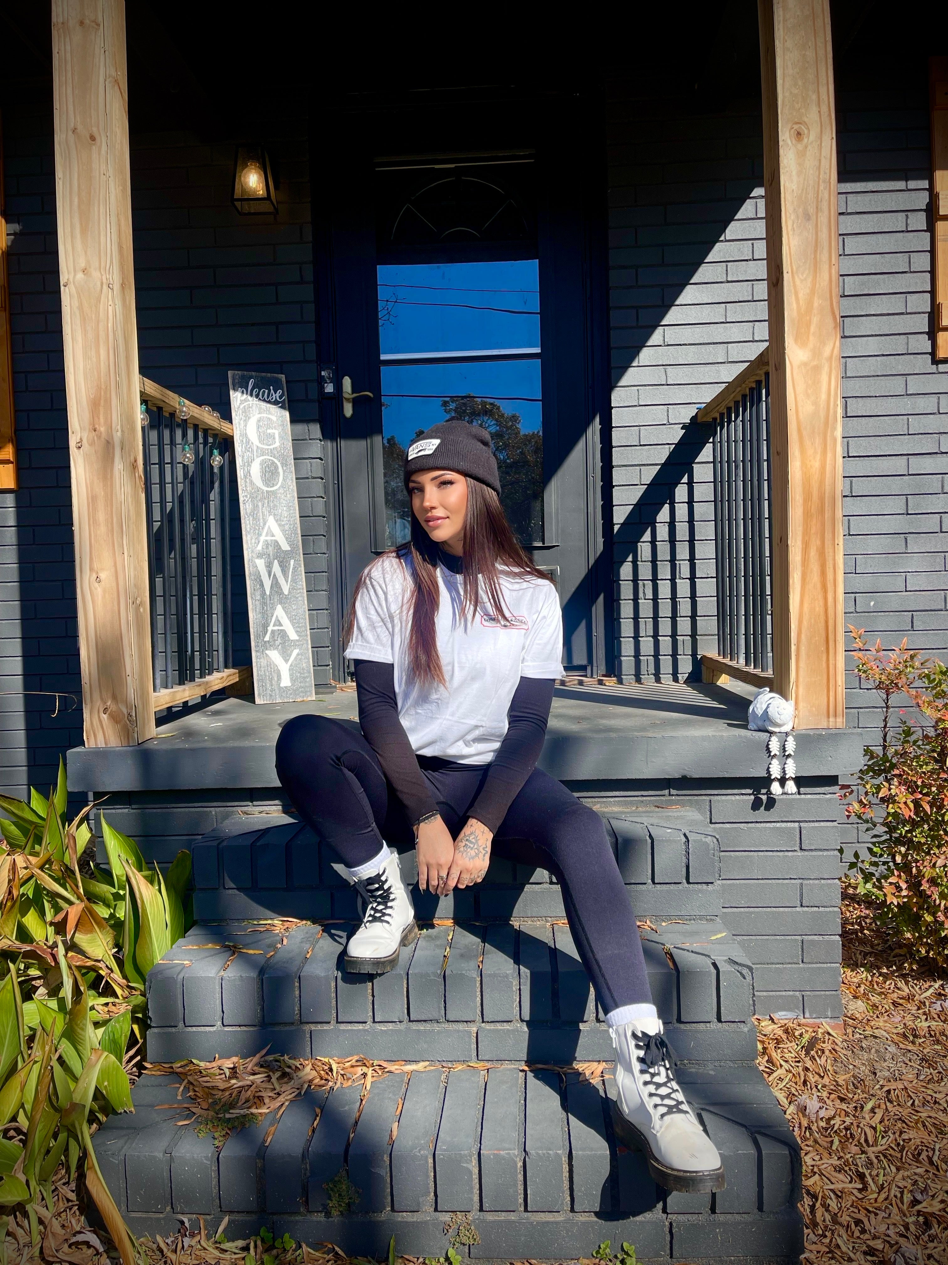 Person sitting on steps outside a house with a blue door Microgods Flash Tee - Ghost and Darkness